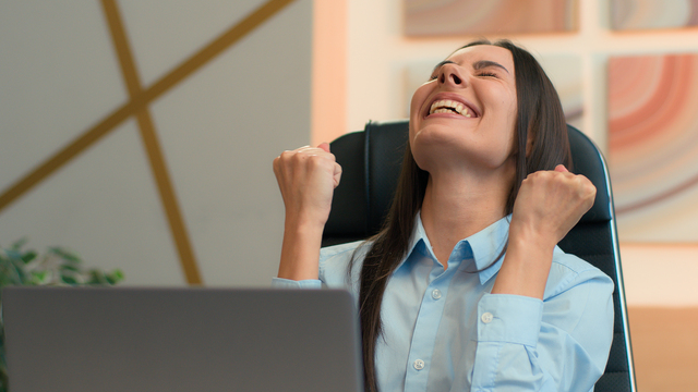 Applicant celebrating good news at a laptop