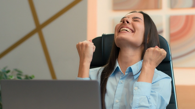 Applicant celebrating good news at a laptop
